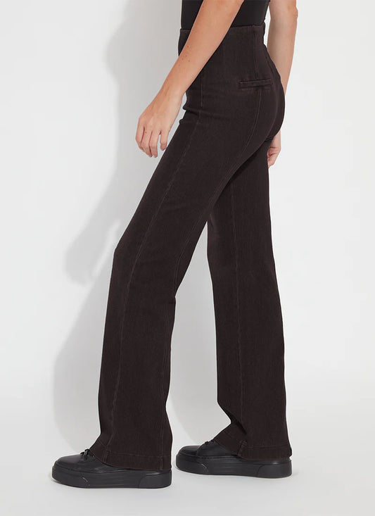 A model wearing dark brown wide-leg pants and black platform shoes, shown from a side-rear angle against a light gray studio background.