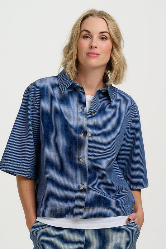 Woman wearing a blue striped shirt and pants on a white background