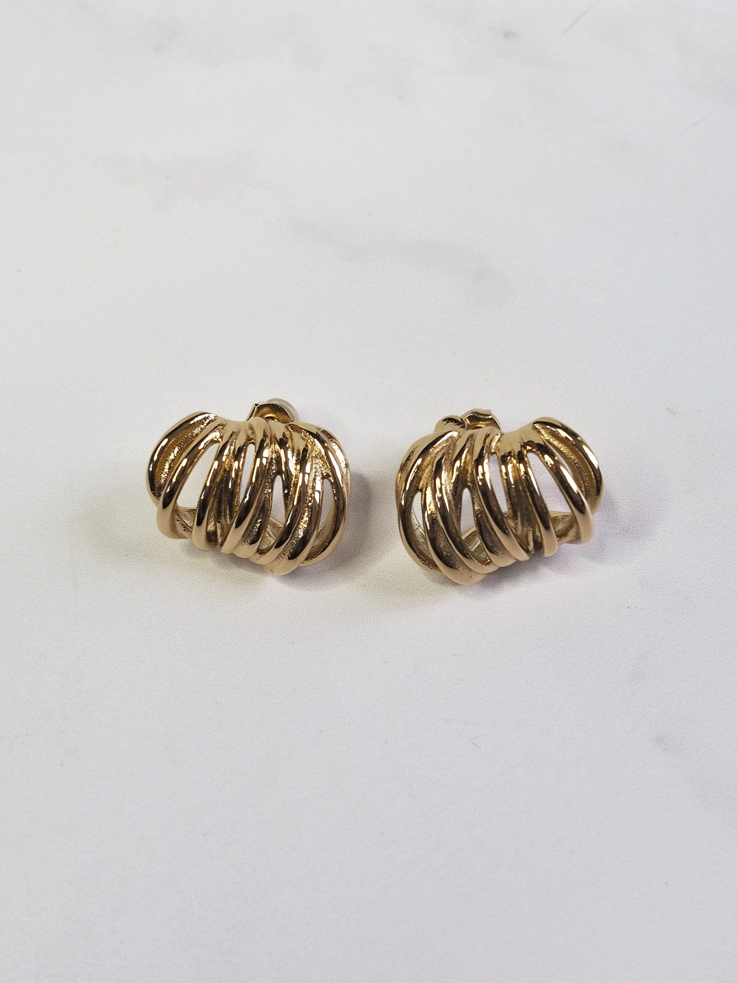 Pair of gold hoop earrings on a light gray background