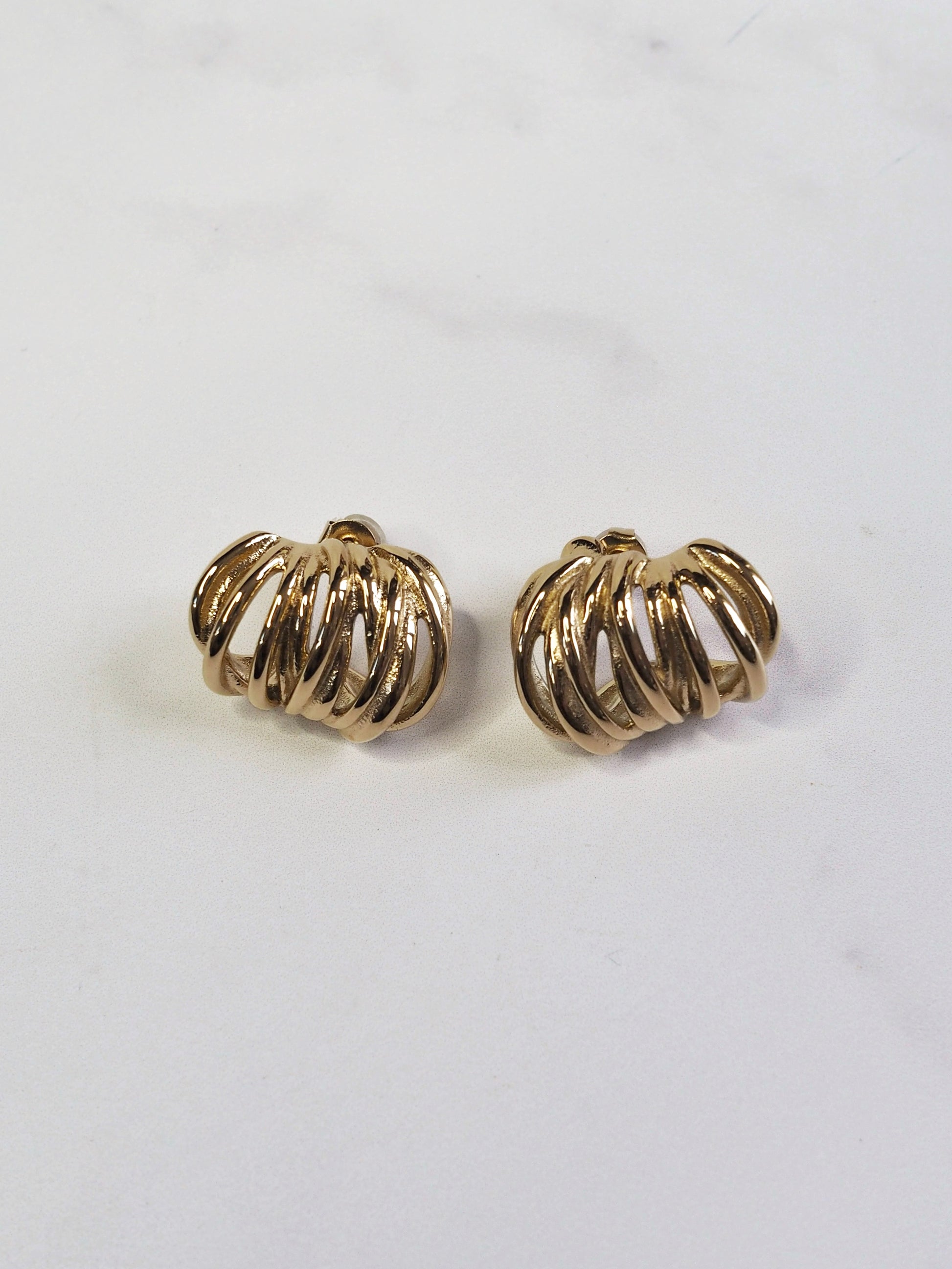 Pair of gold hoop earrings on a light gray background