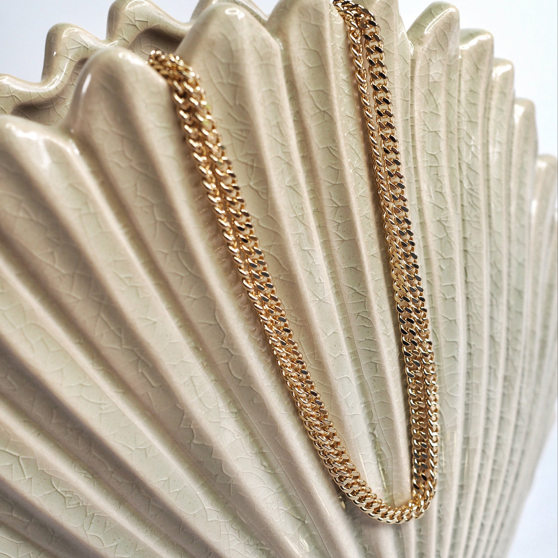 Gold chain necklace on a decorative shell