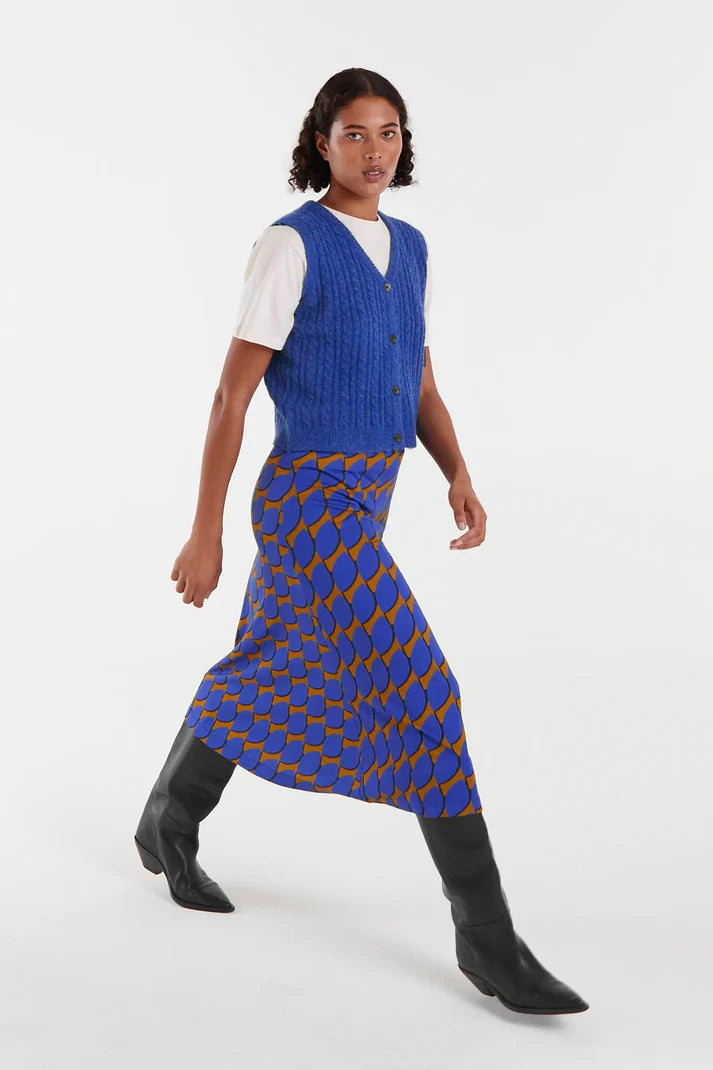 Woman wearing a blue patterned dress over a white shirt on a white background
