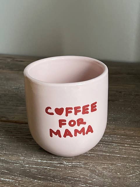 Pink mug with 'Coffee for Mama' text on a wooden surface