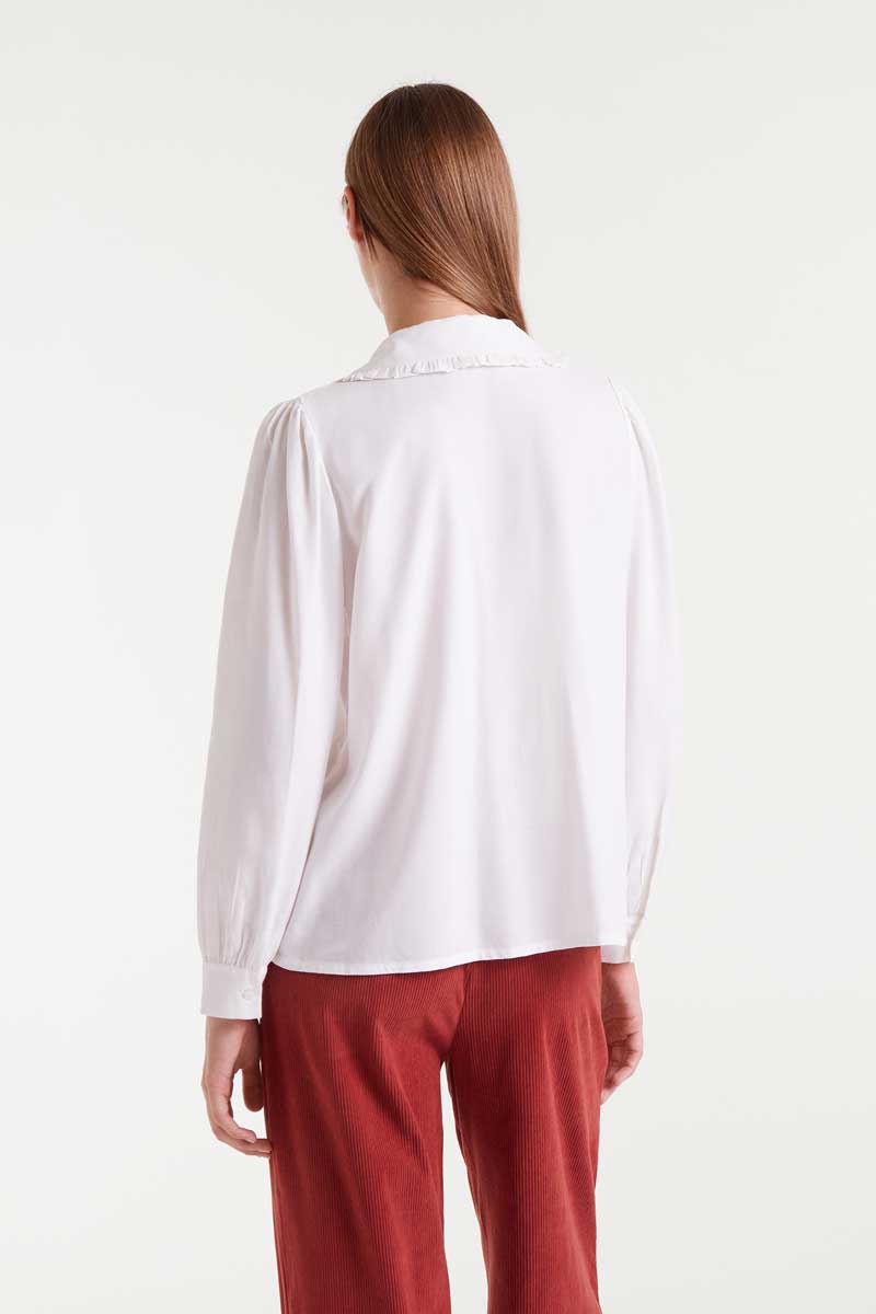 Person wearing a white shirt and red pants on a white background