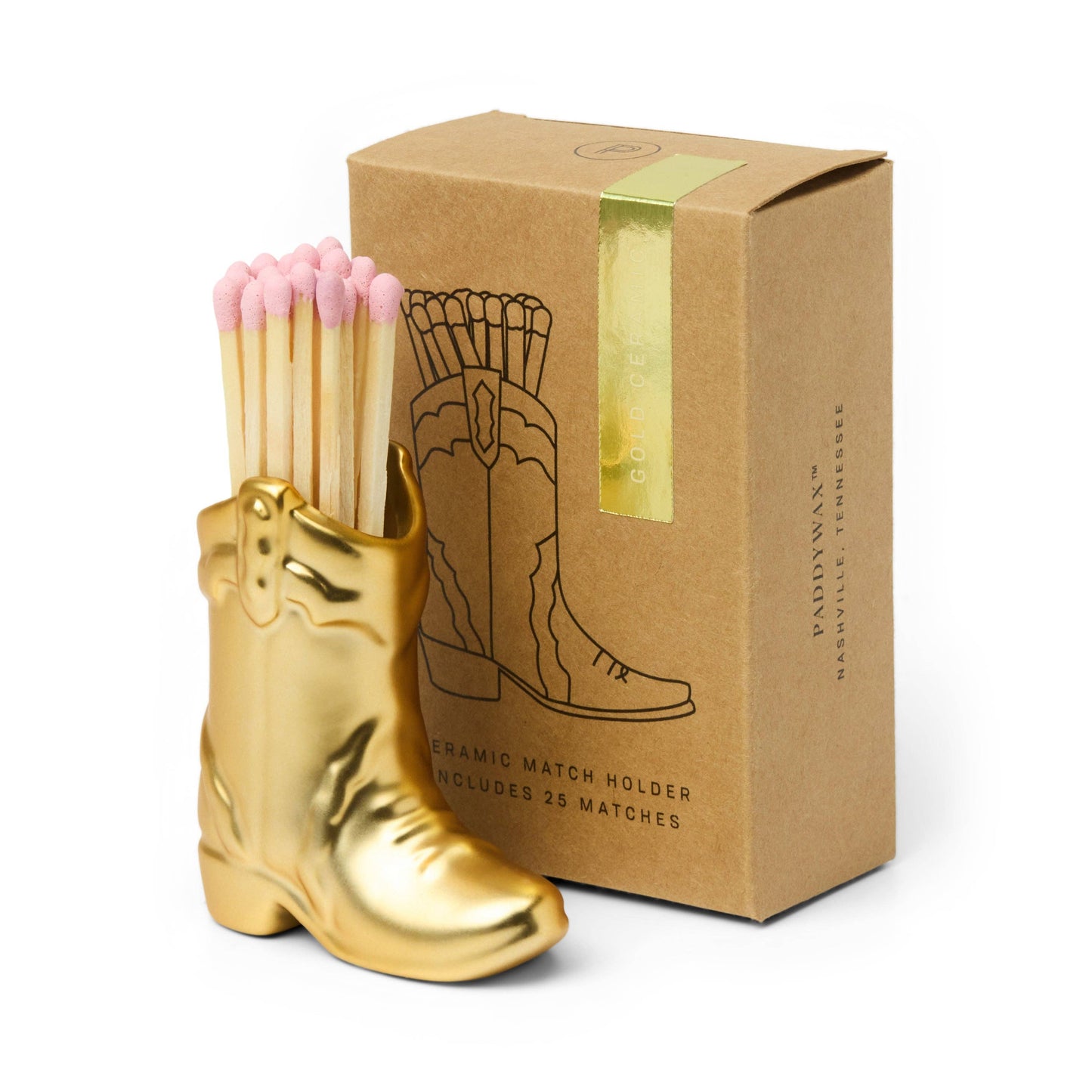 Gold boot-shaped match holder with pink matches next to a brown box on a white background