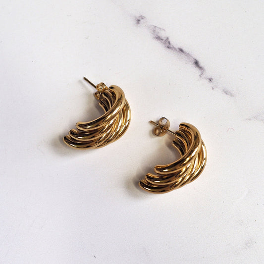 Gold hoop earrings on a marble surface