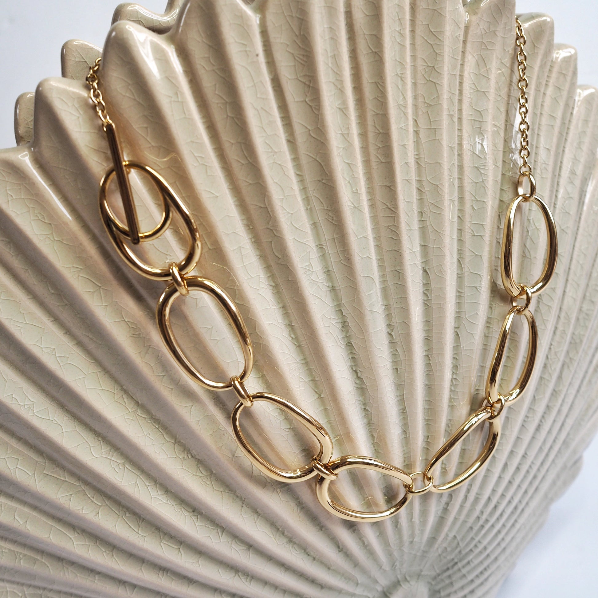 Gold chain necklace on a seashell