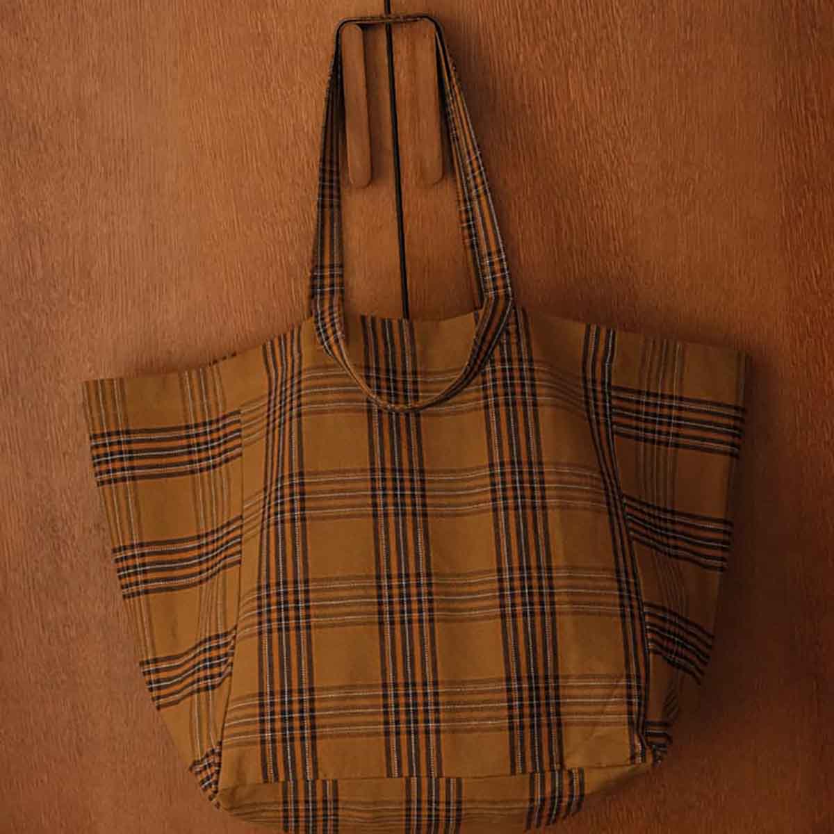 brown plaid bag on a wooden surface