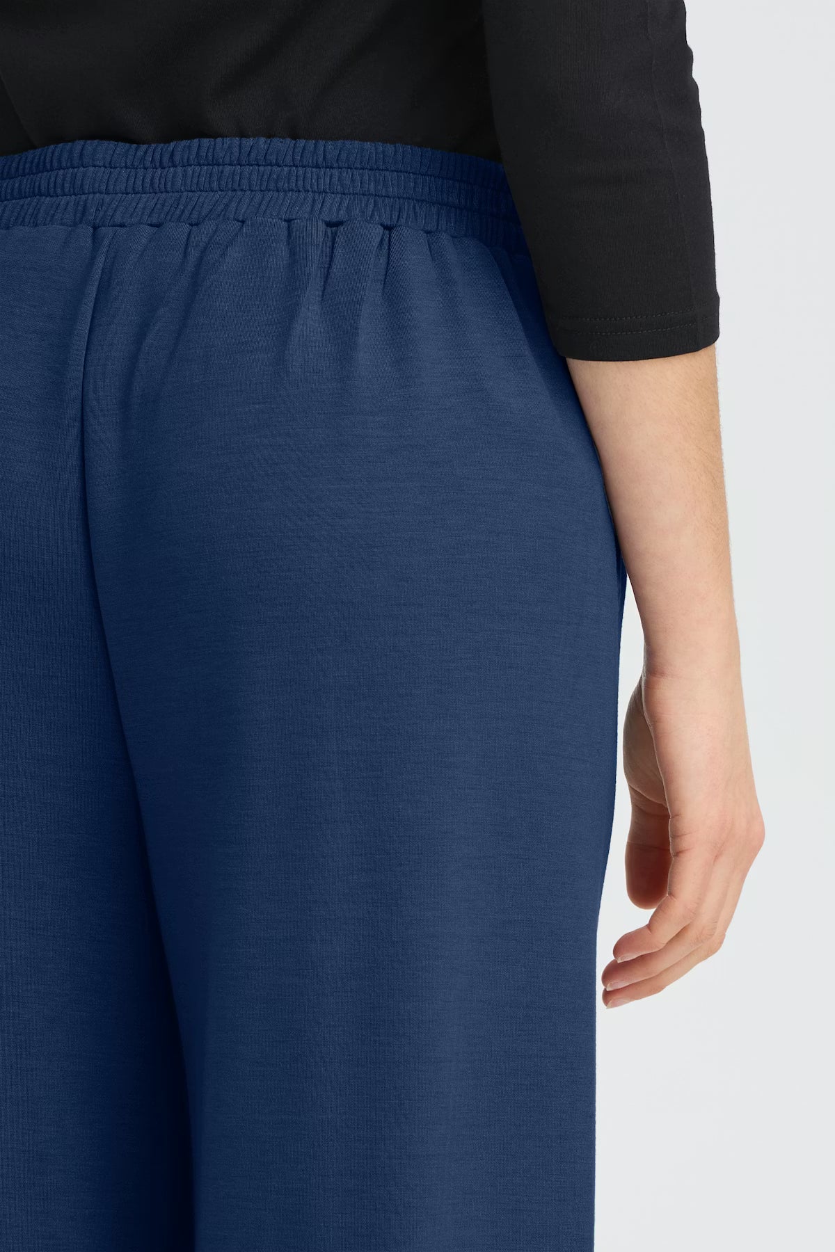 Blue pants worn by a person on a white background