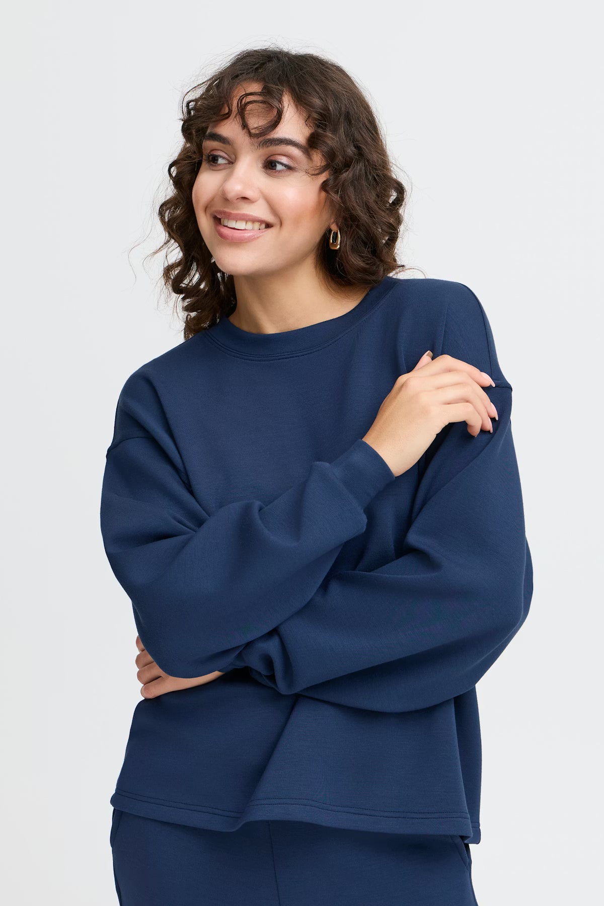 Woman wearing a blue sweatshirt against a white background
