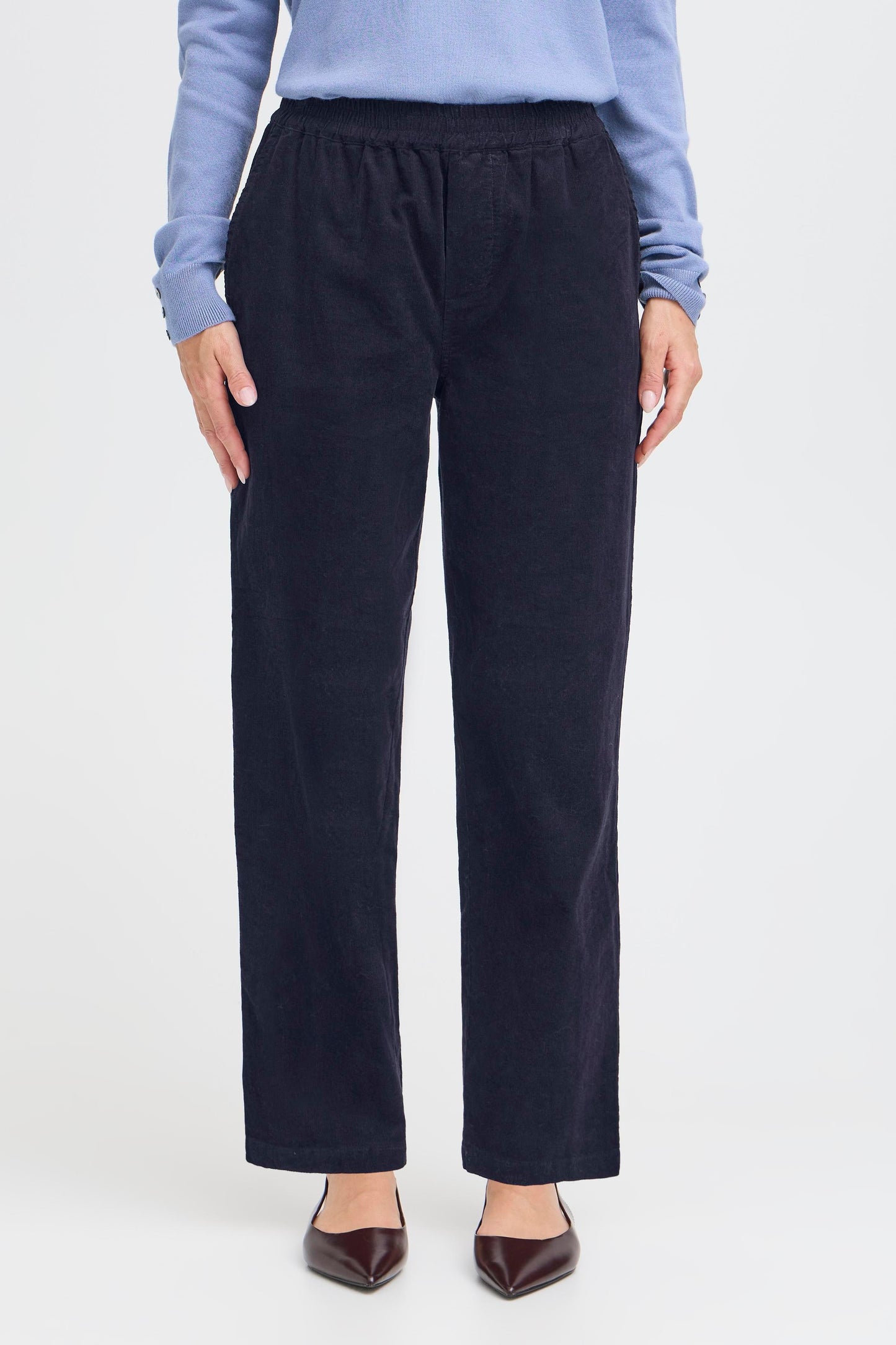 Person wearing navy pants on a white background