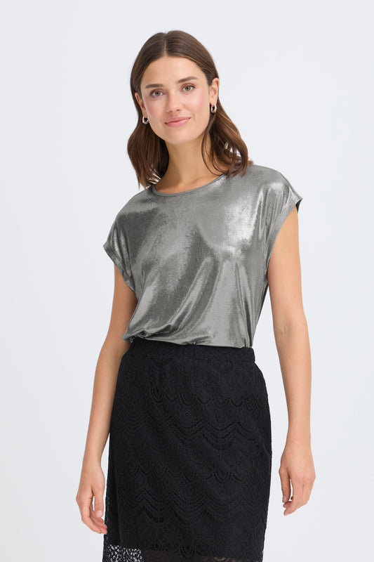 Woman wearing a silver metallic top and black skirt on a white background