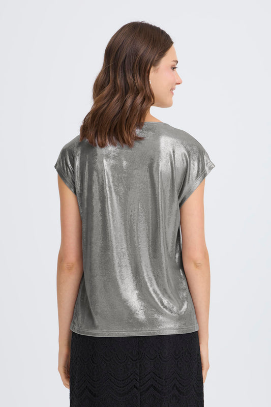 Woman wearing a silver metallic top on a white background