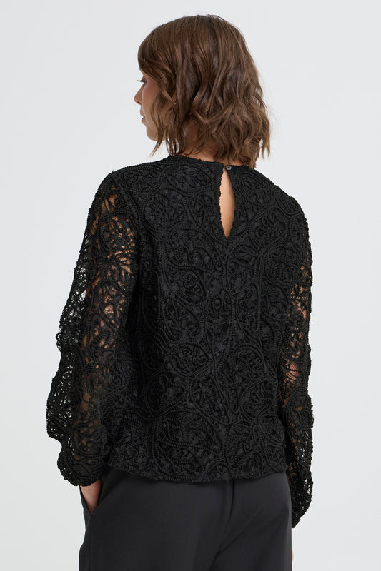 Black lace top worn by a person on a white background