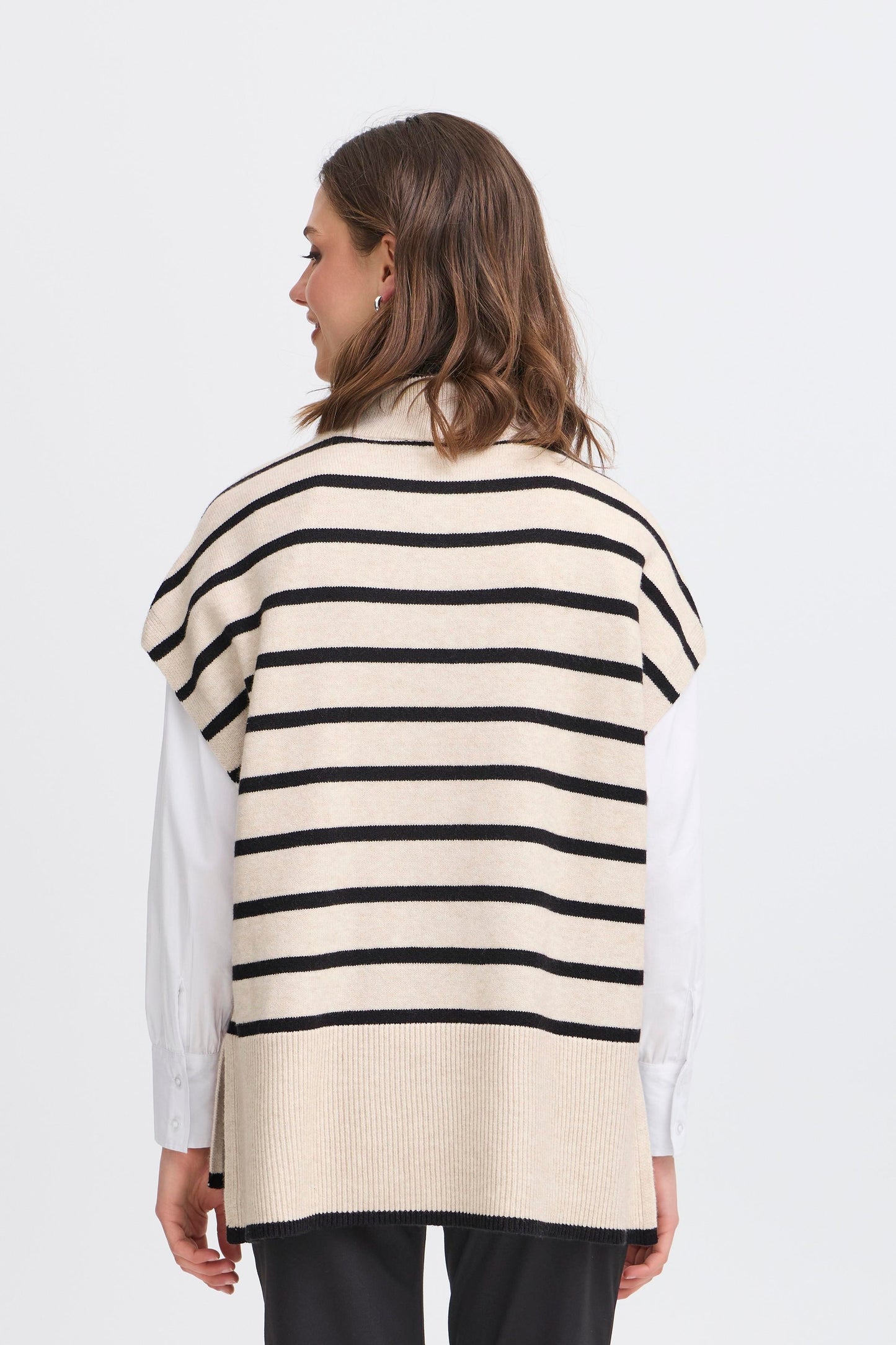 Woman wearing a striped sweater vest on a white background