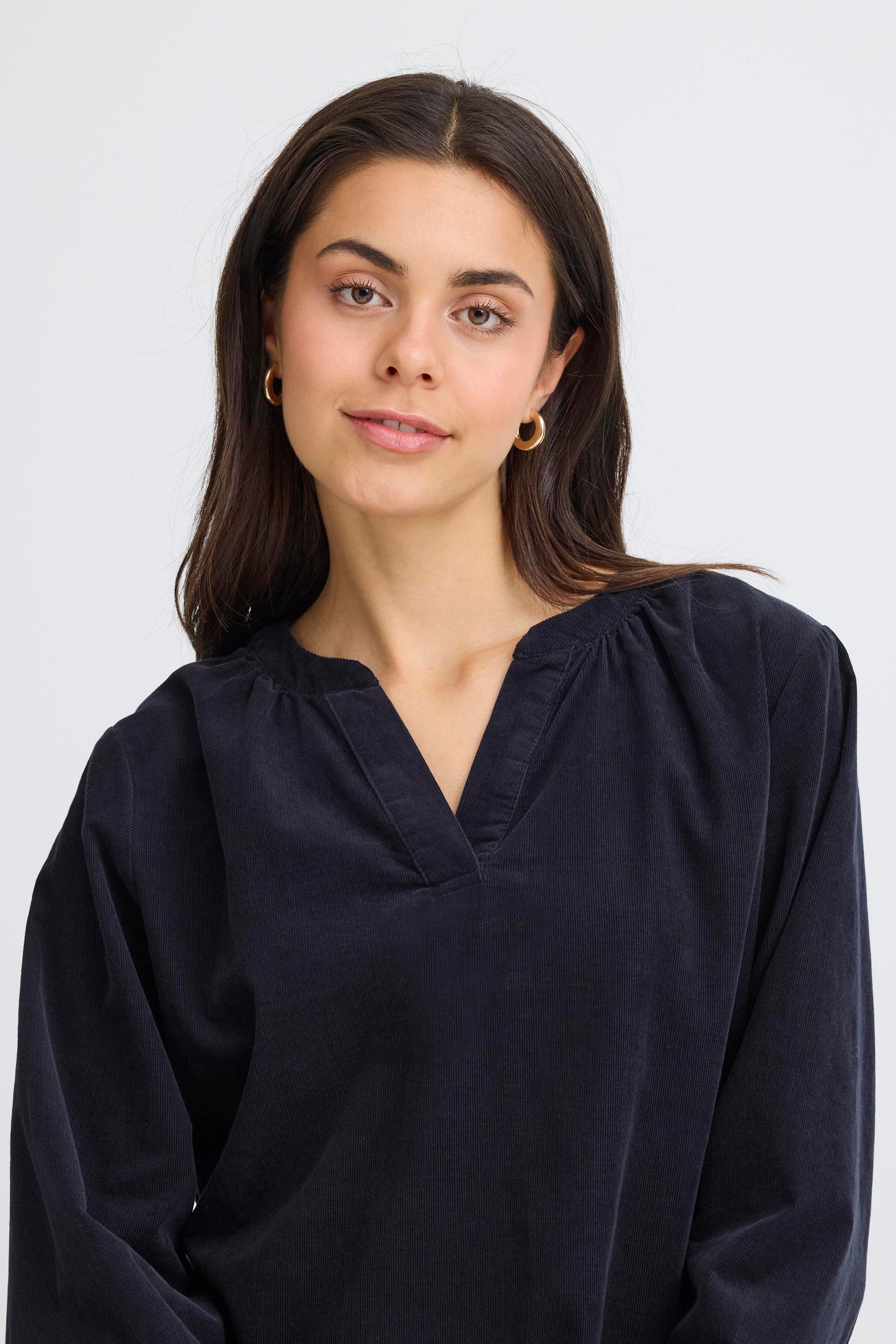 Woman wearing a dark blue blouse against a white background