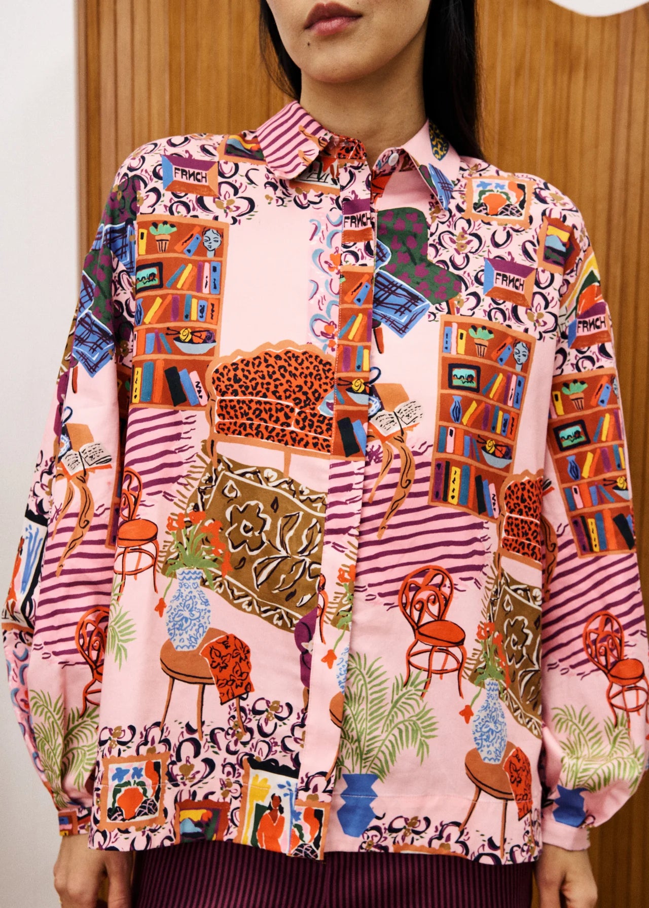 Person wearing a colorful patterned shirt with various designs.