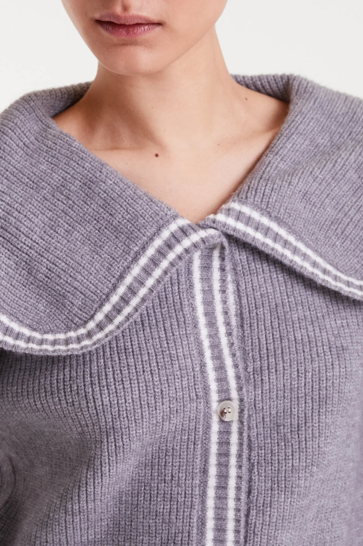Close-up of a gray knitted cardigan with white trim