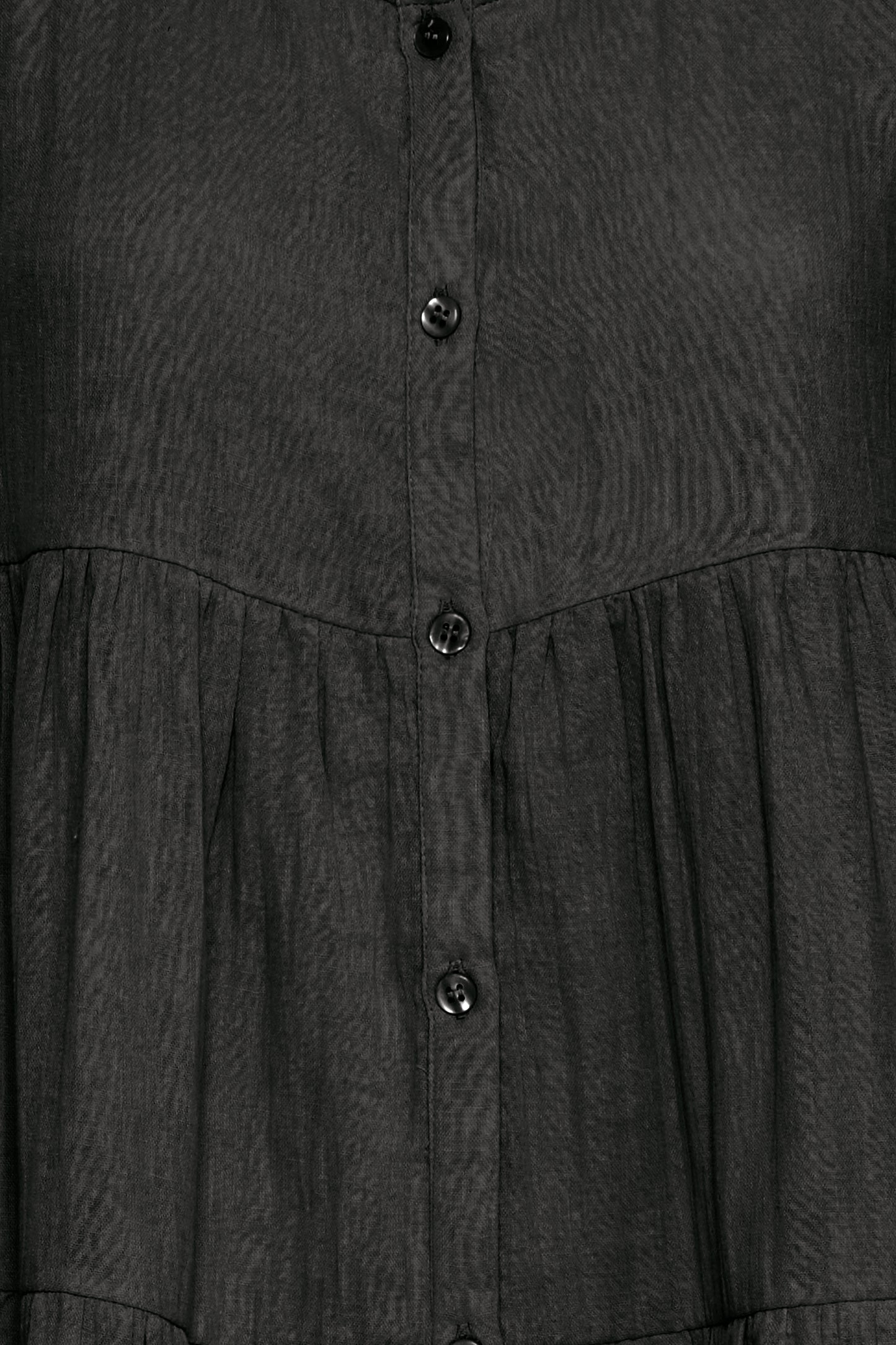 Close-up of a dark gray dress with buttons on a plain background