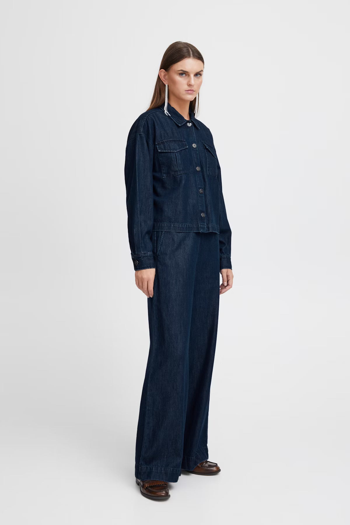 Person wearing a dark denim outfit on a white background