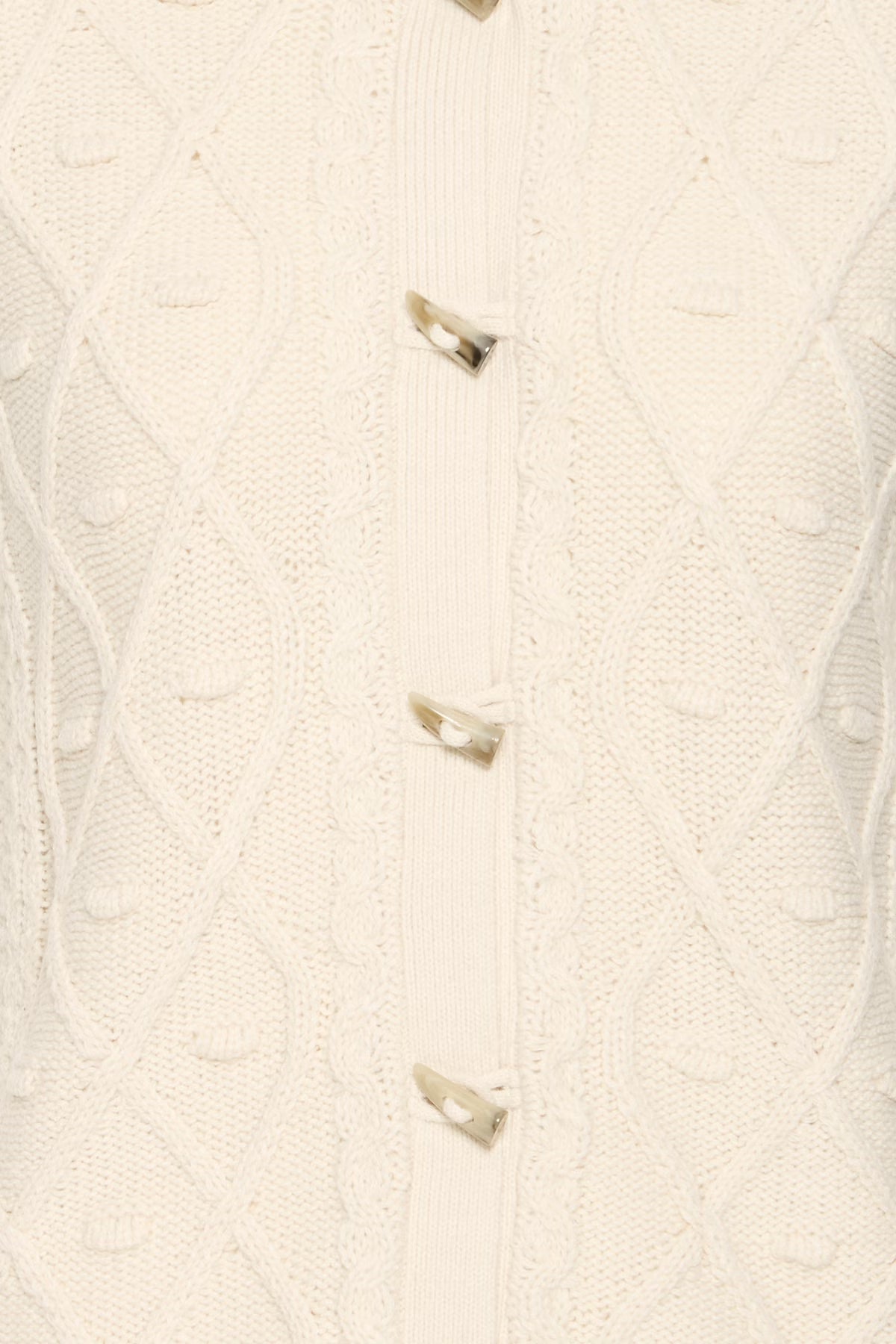 Close-up of a cream-colored knitted cardigan with buttons on a white background