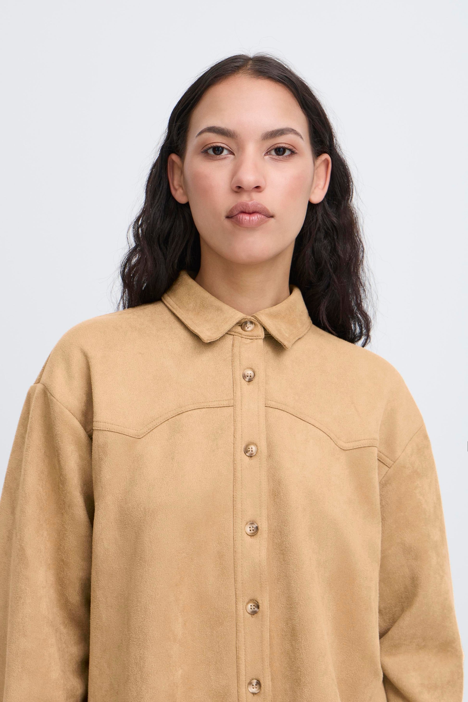 Woman wearing a beige shirt against a white background