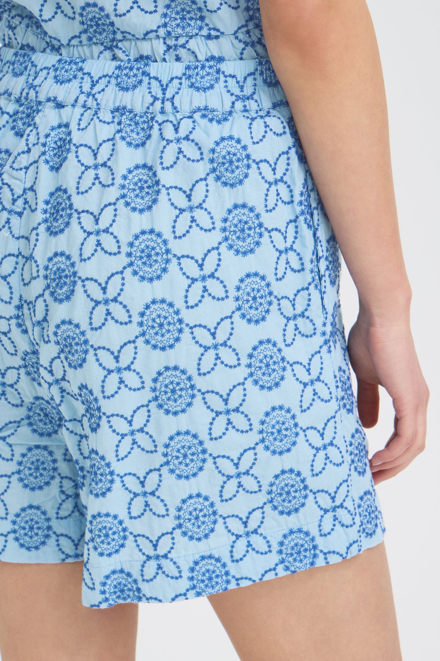 Blue floral patterned shorts on a white background