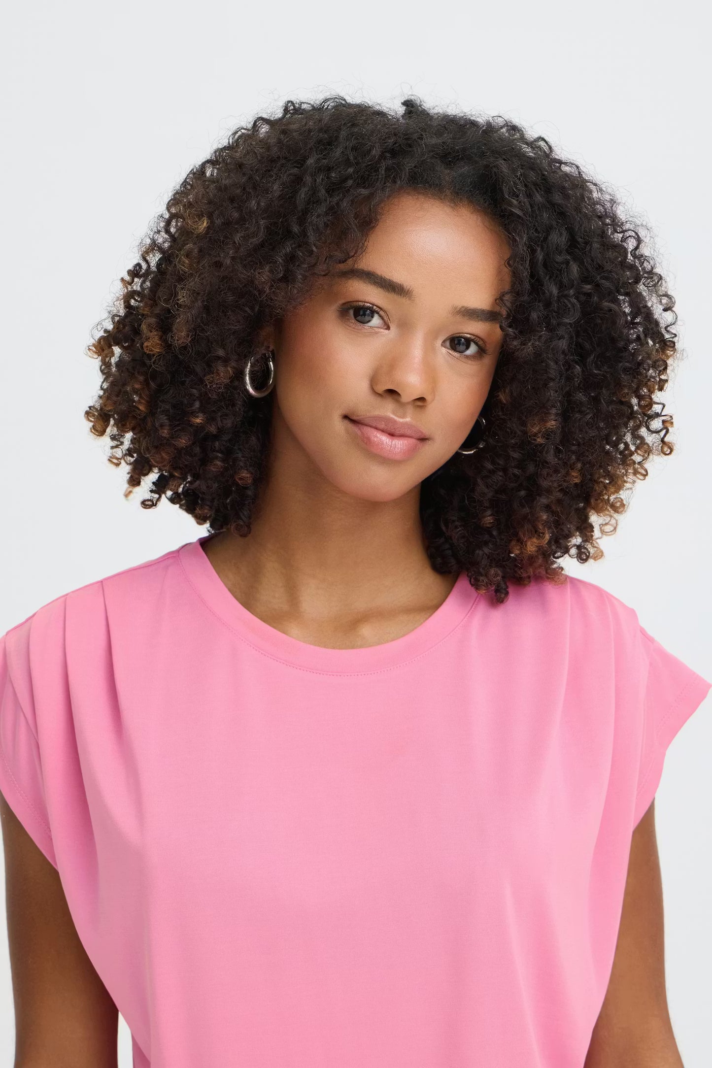 Woman wearing a pink top against a white background