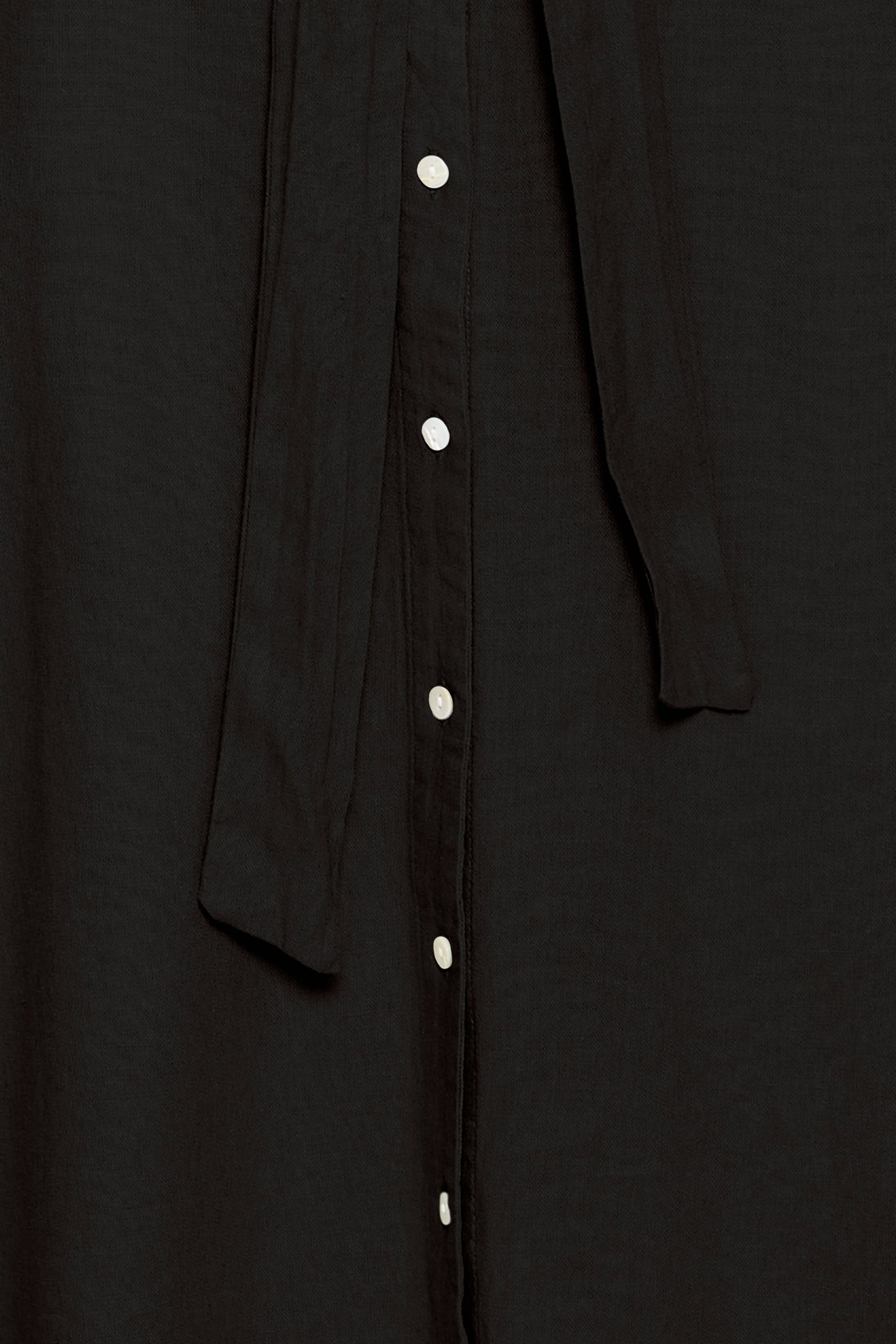 Close-up of a black button-up shirt with a plain background