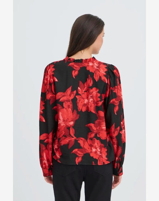 Woman wearing a black blouse with red floral pattern on a white background