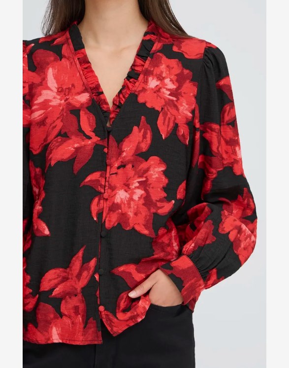 Black blouse with red floral pattern worn by a person