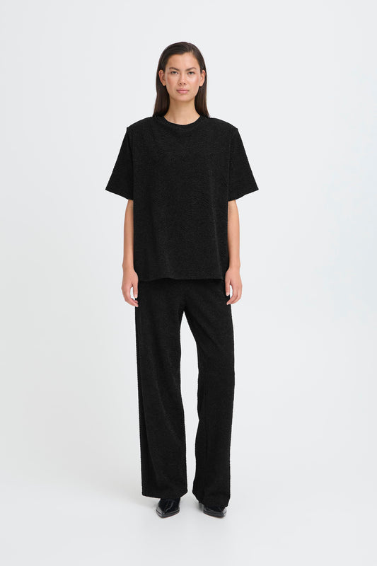 Person wearing a black outfit on a white background
