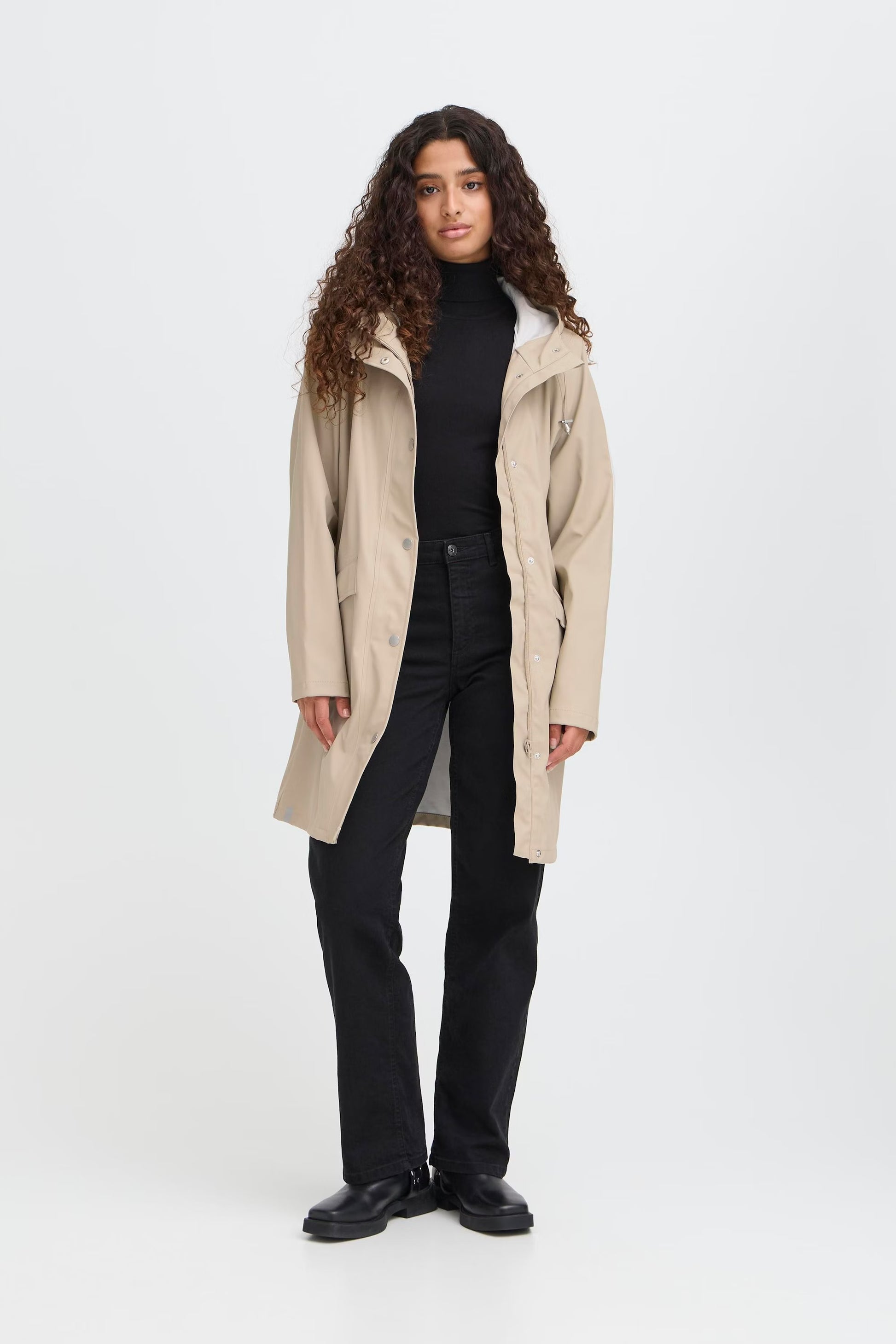 Woman wearing a beige raincoat on a white background