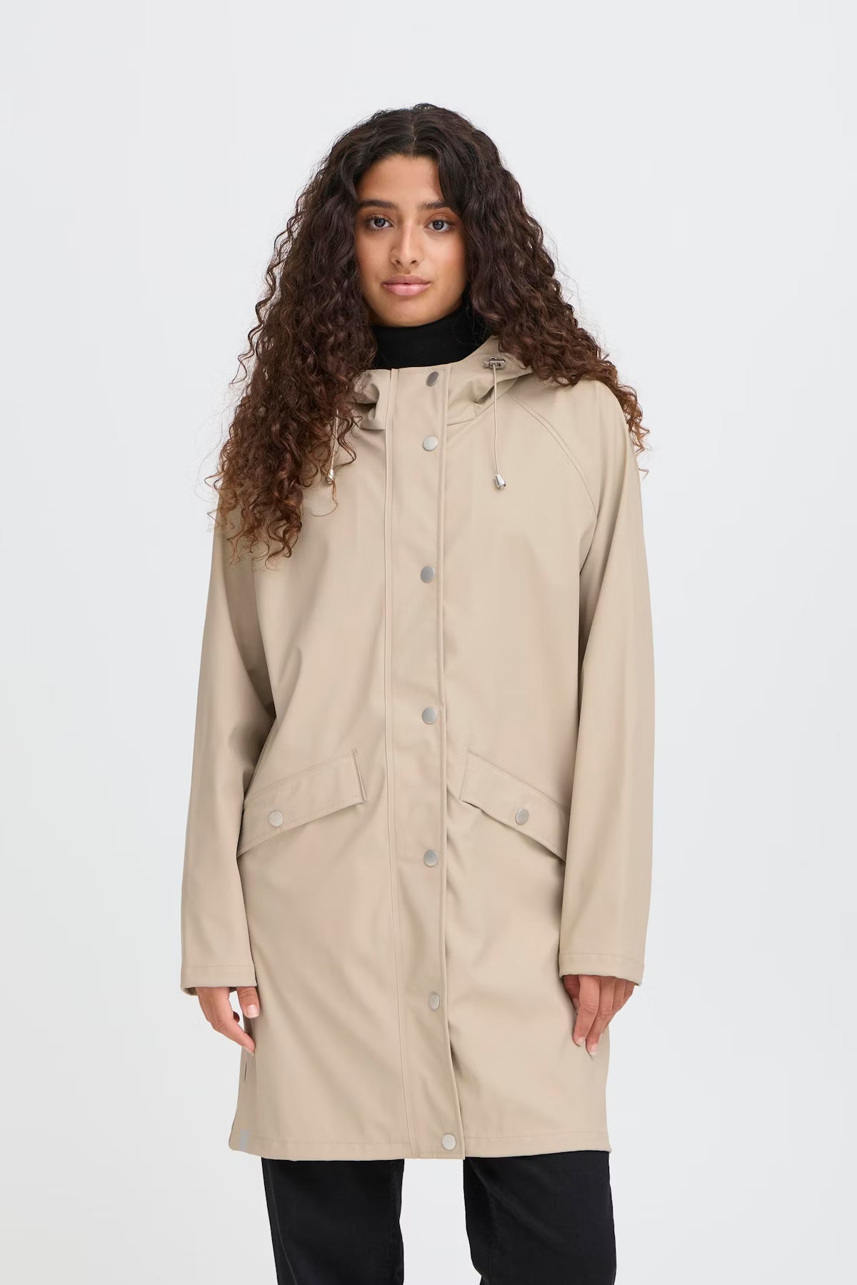 Woman wearing a beige coat on a white background