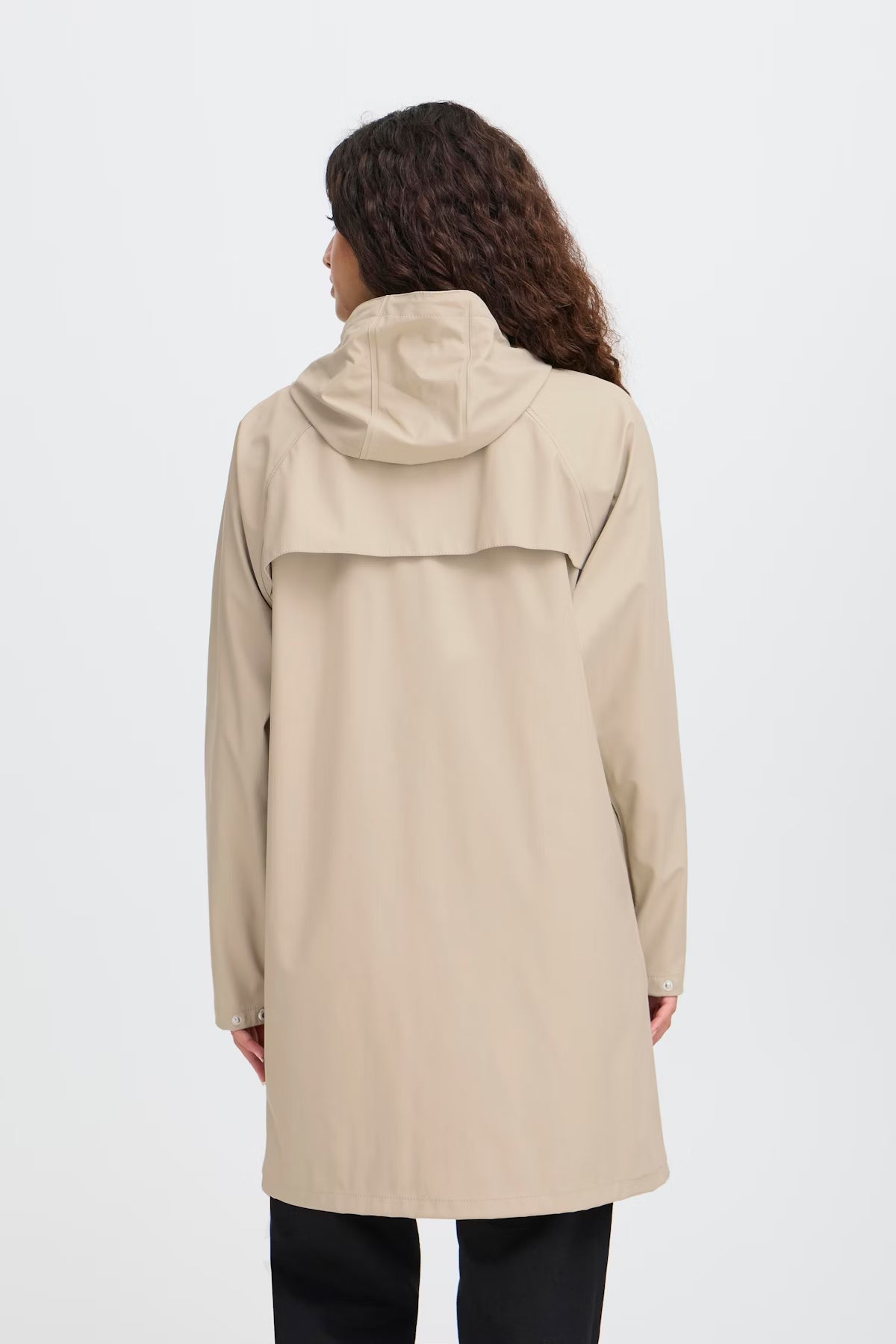 Person wearing a beige raincoat on a white background