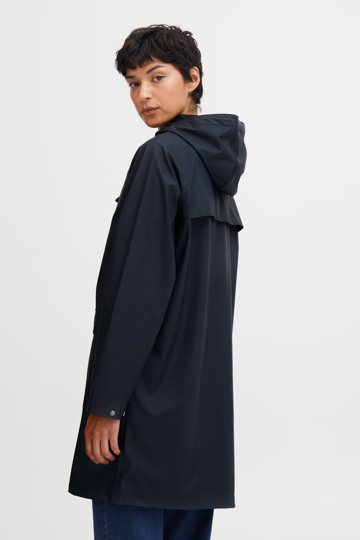 Person wearing a navy raincoat on a white background