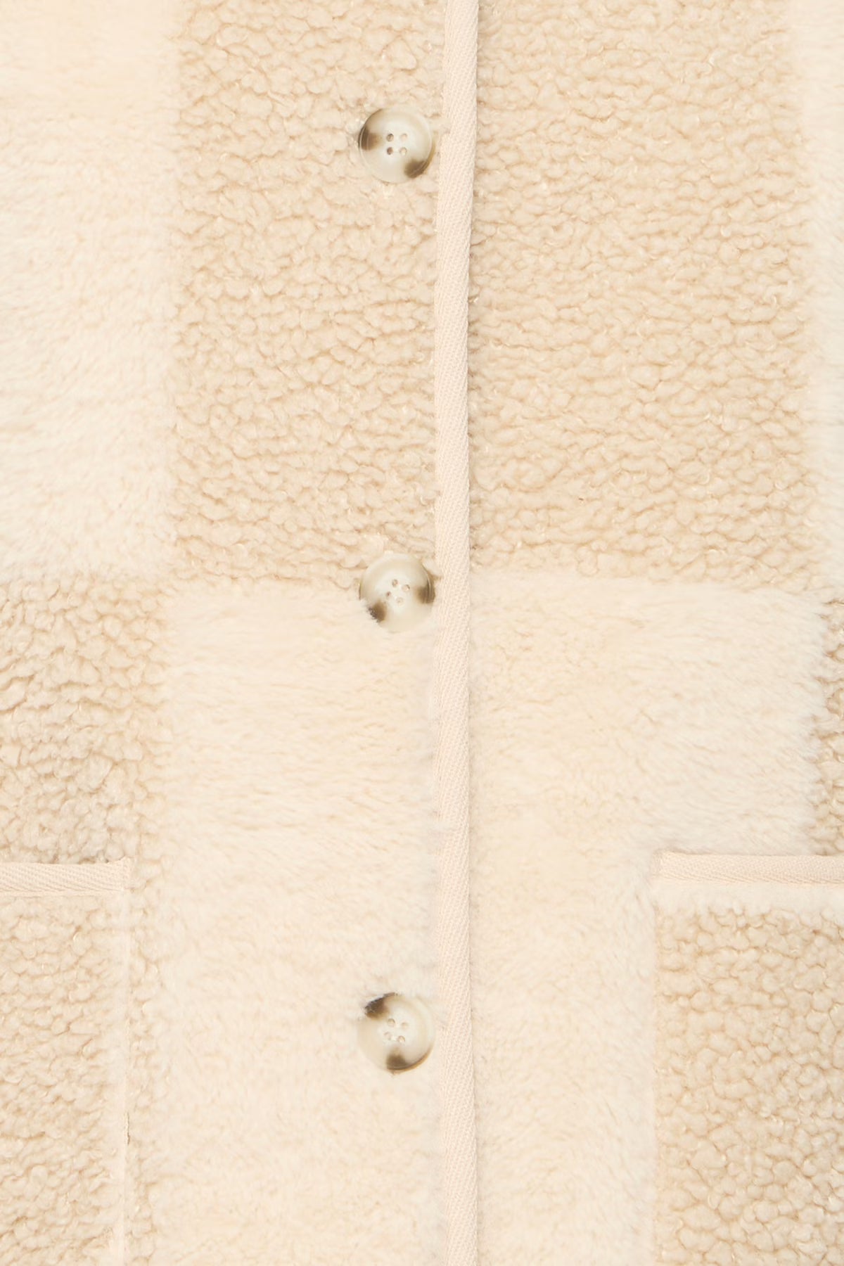 Close-up of a beige textured fabric with buttons