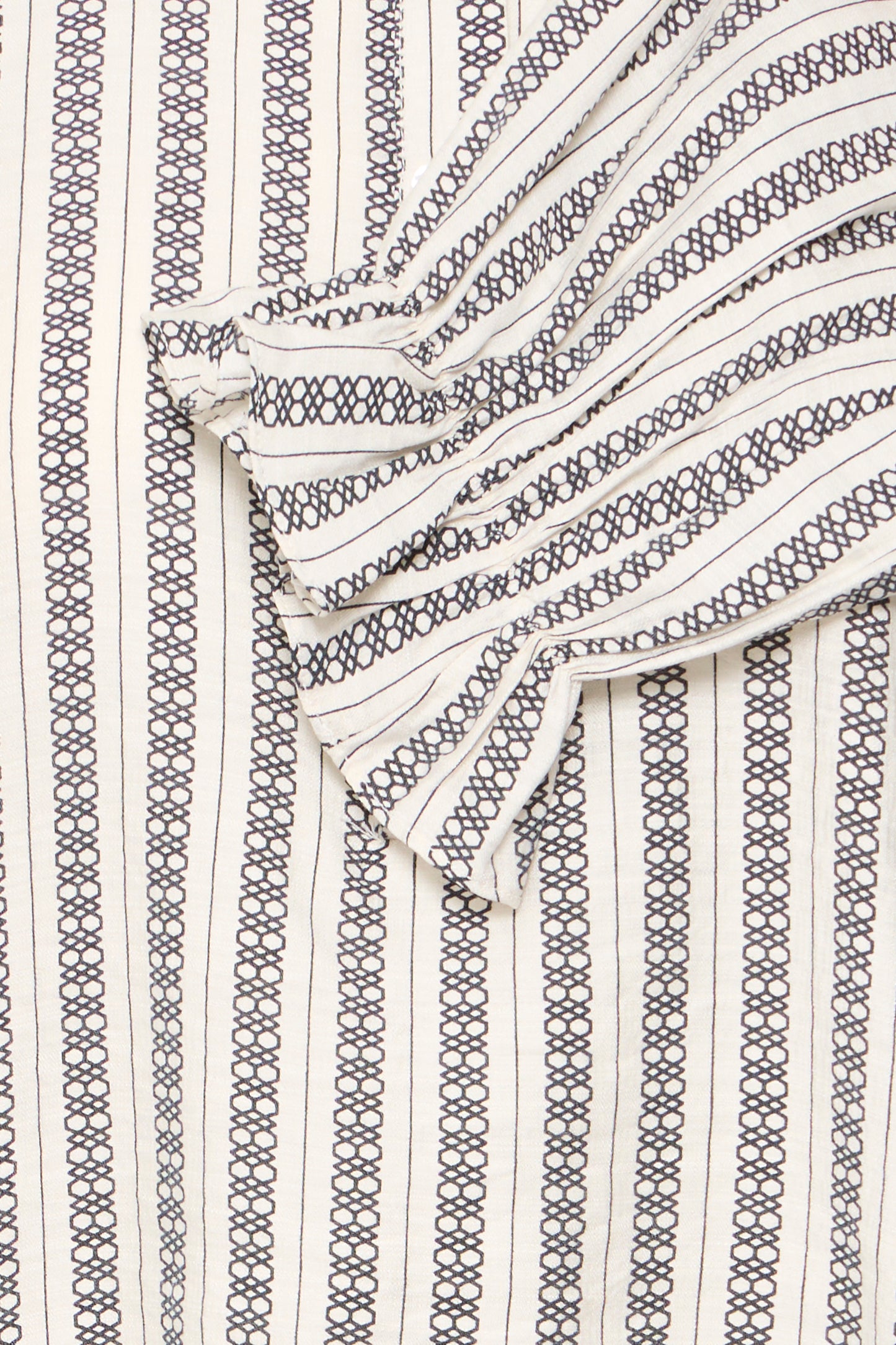 Close-up of a patterned fabric with black and white lines on a textured background