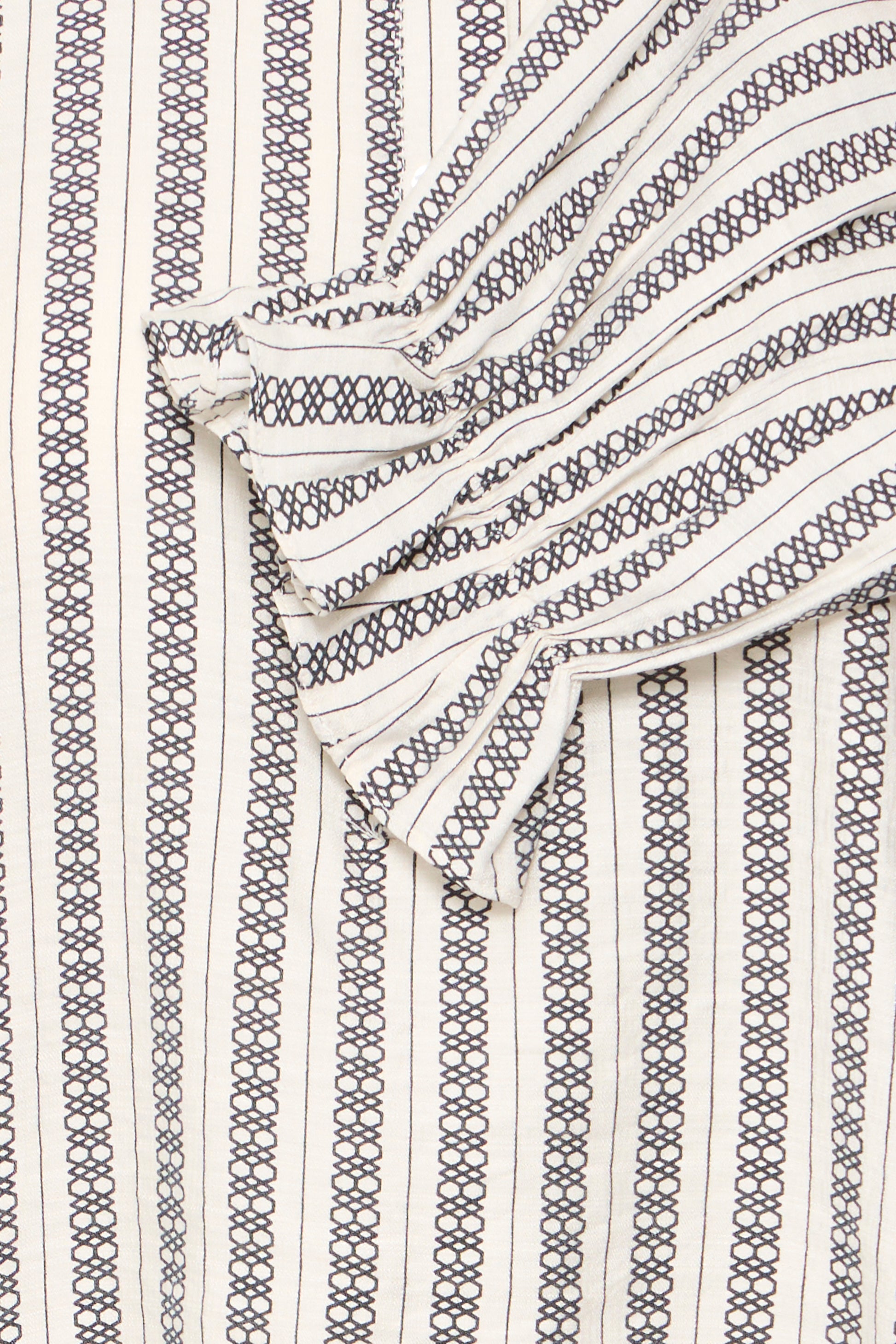 Close-up of a patterned fabric with black and white lines on a textured background