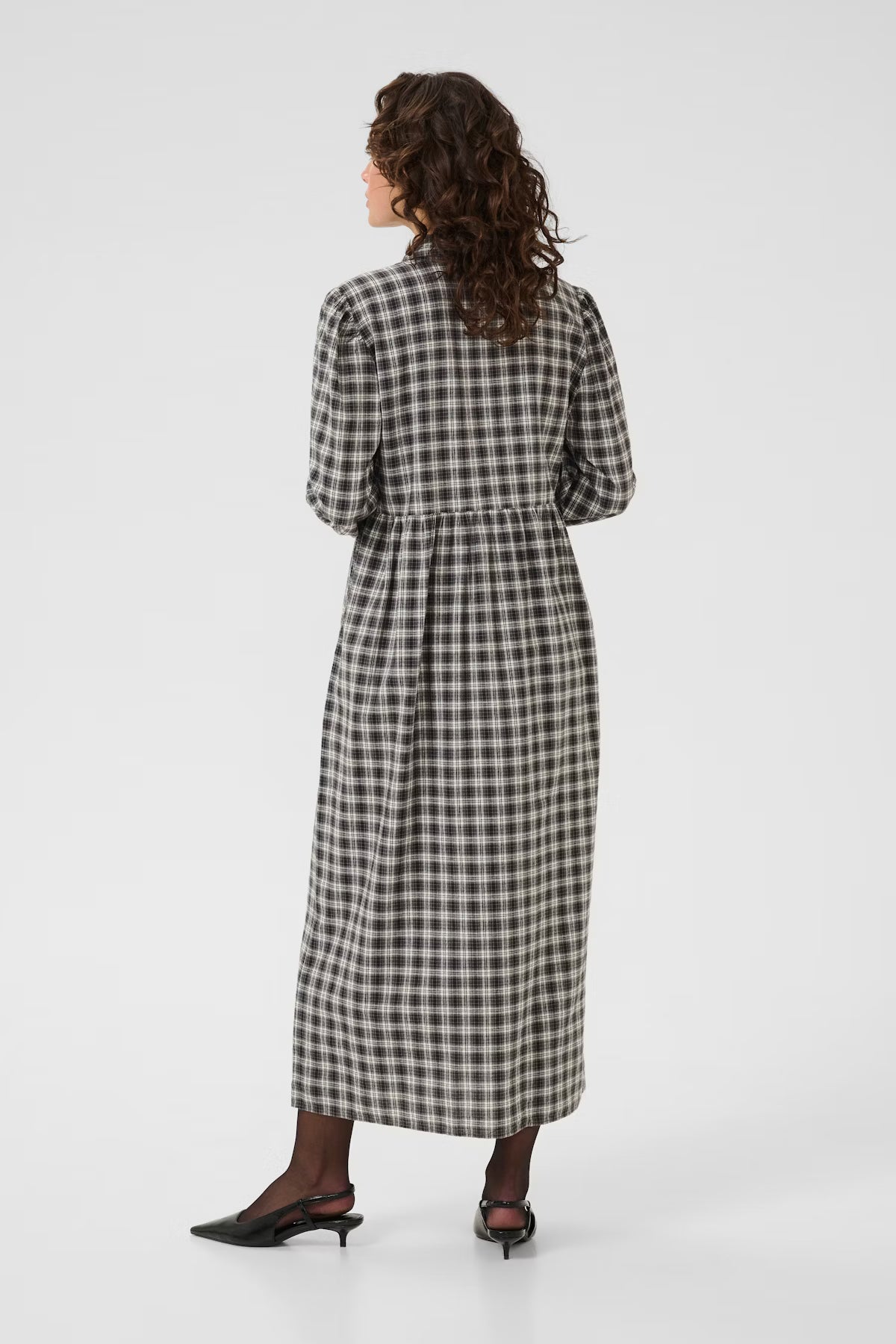 Woman wearing a black and white checkered dress on a white background