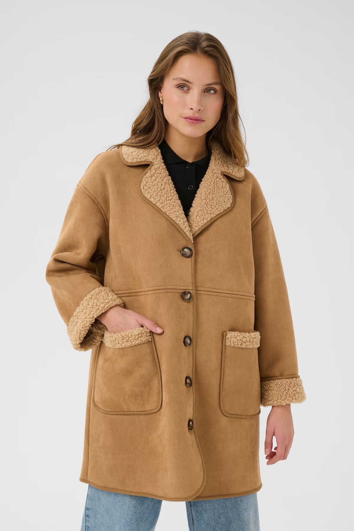 Woman wearing a brown coat with sherpa lining on a white background