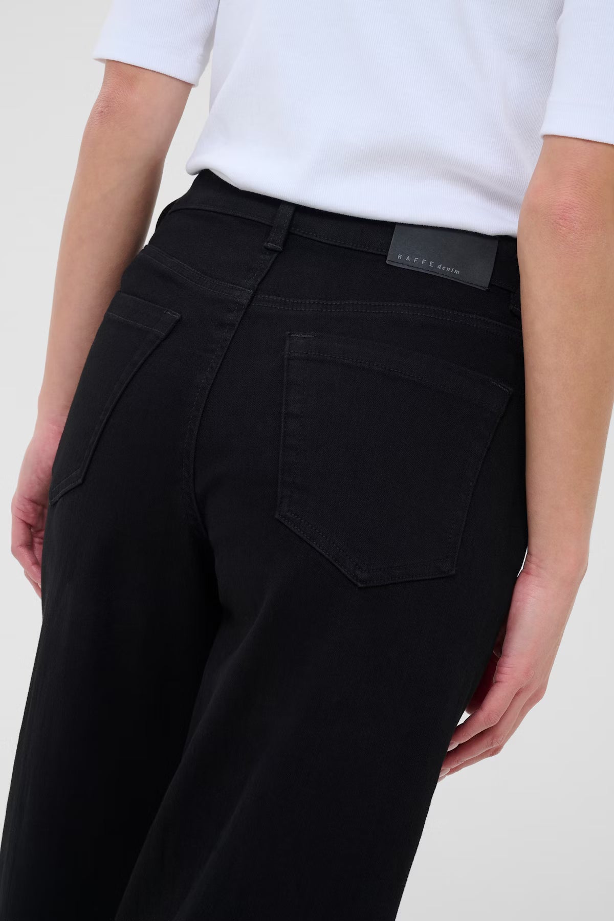 Black jeans with a visible brand label on a white background