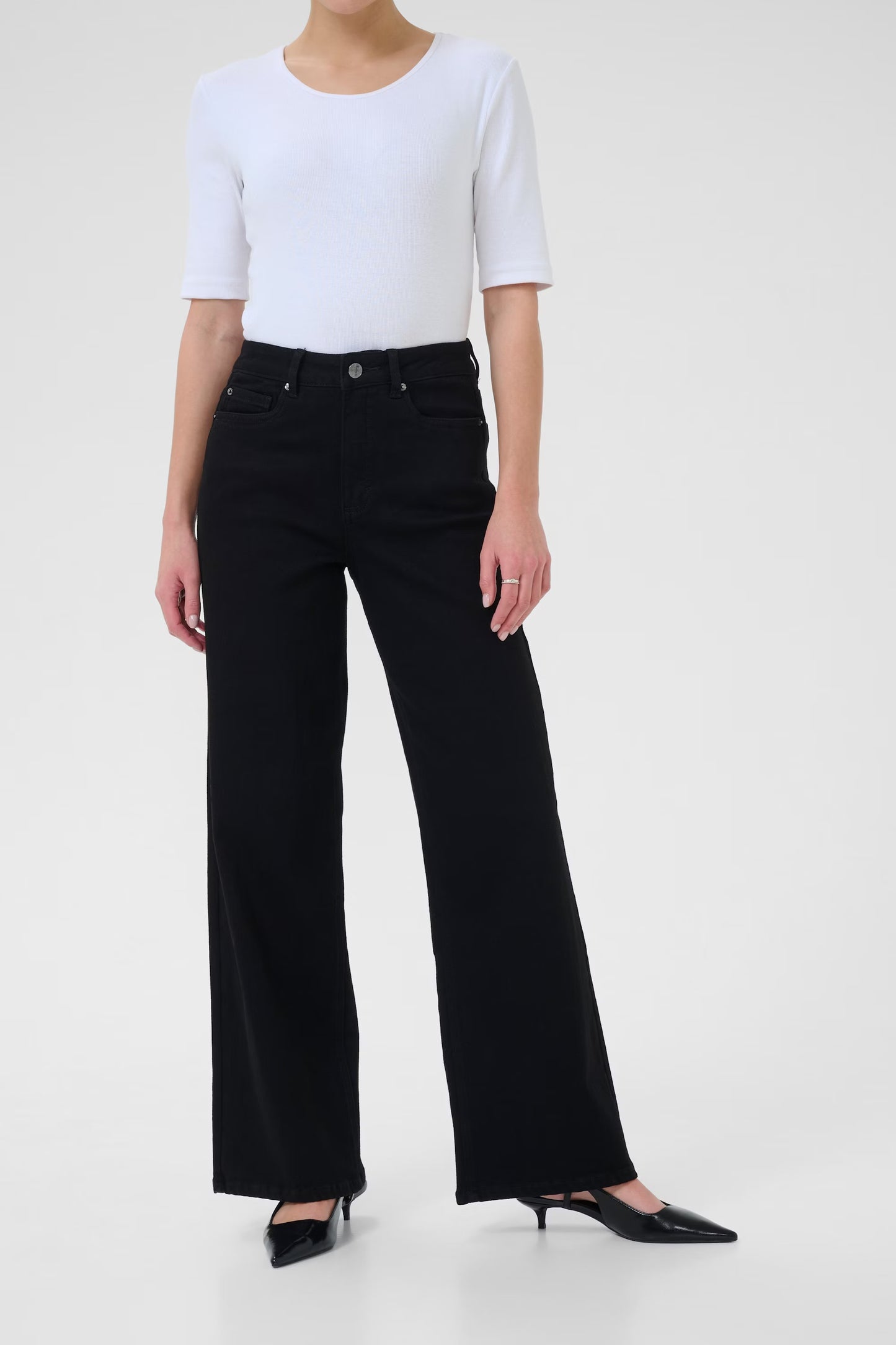 Person wearing a white top and black jeans on a white background