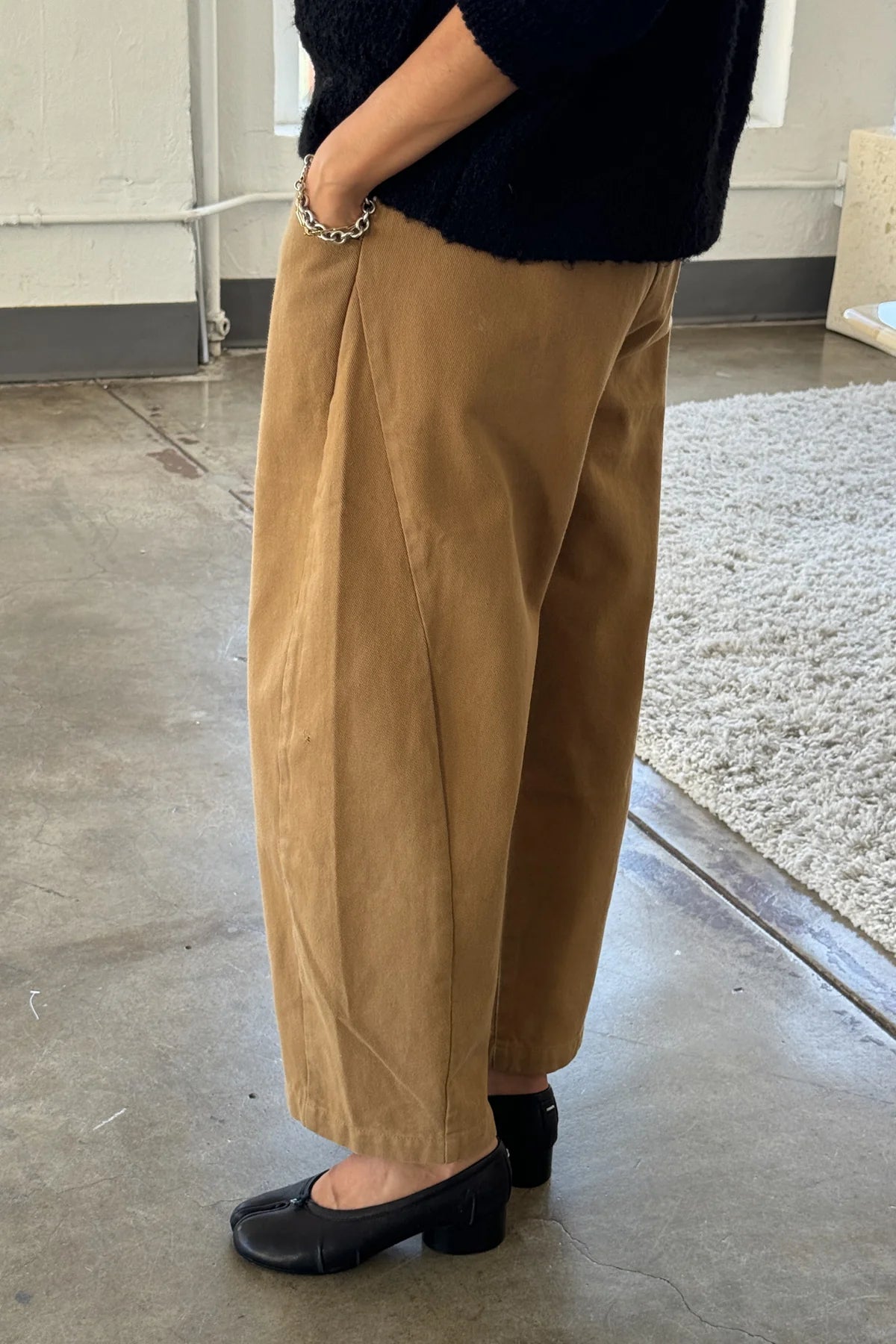 Person wearing beige pants and black shoes indoors.