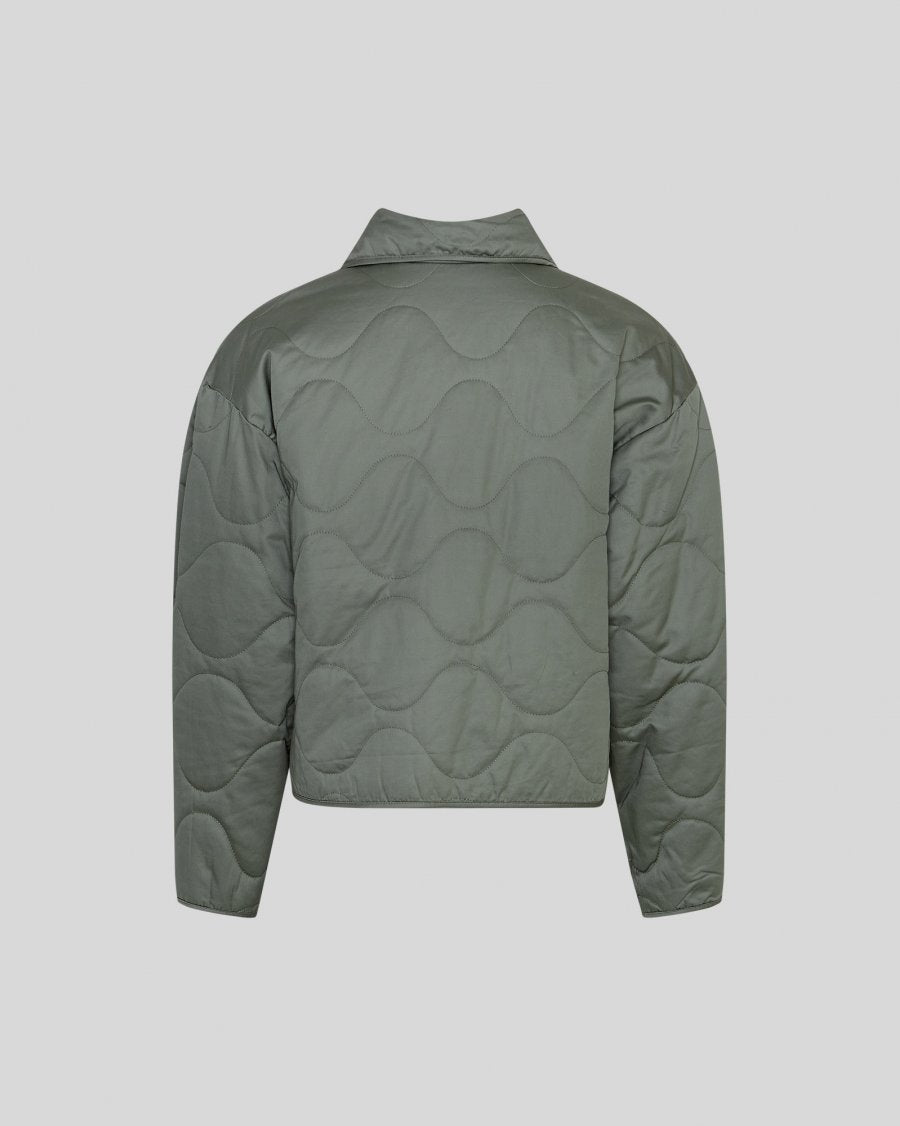Green quilted jacket on a light gray background