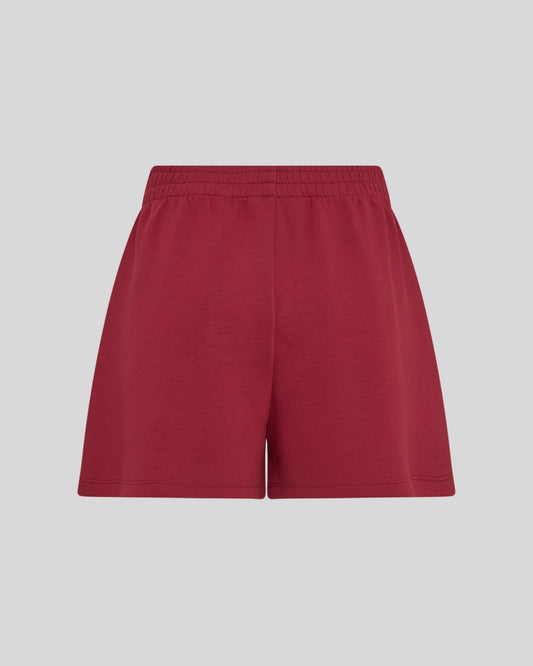 Red sweat shorts on a neutral background