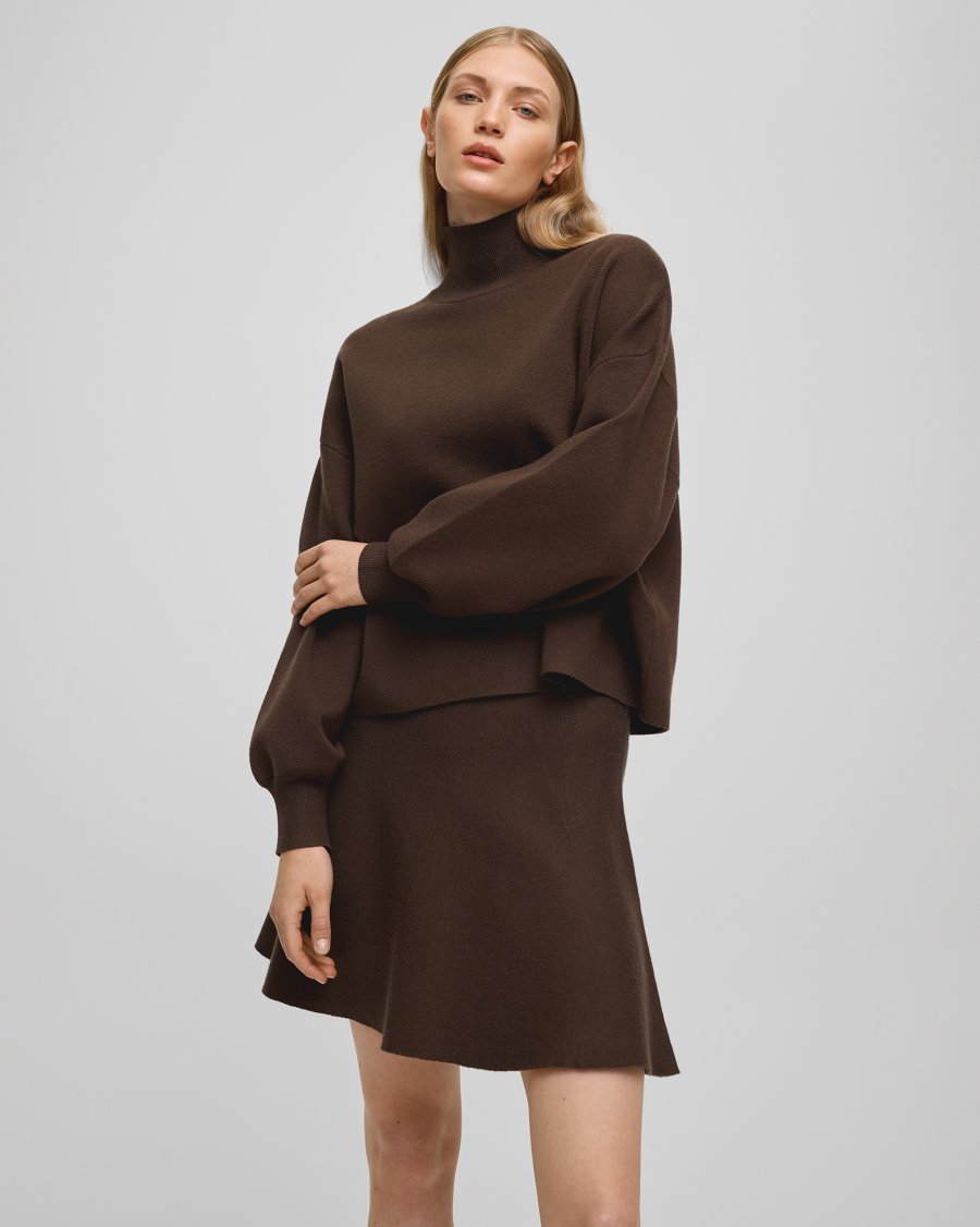 Woman wearing a brown outfit on a plain background