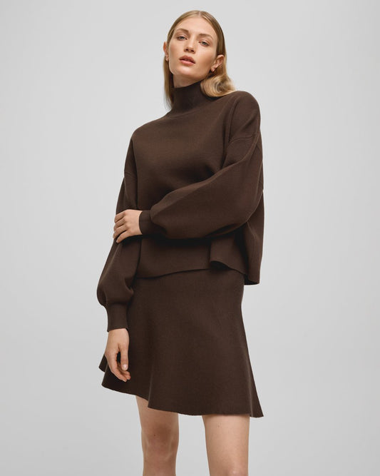 Woman wearing a brown outfit on a plain background