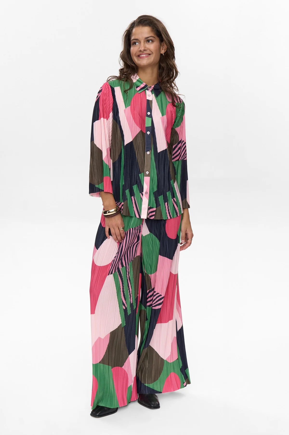 Woman wearing a colorful patterned outfit on a white background
