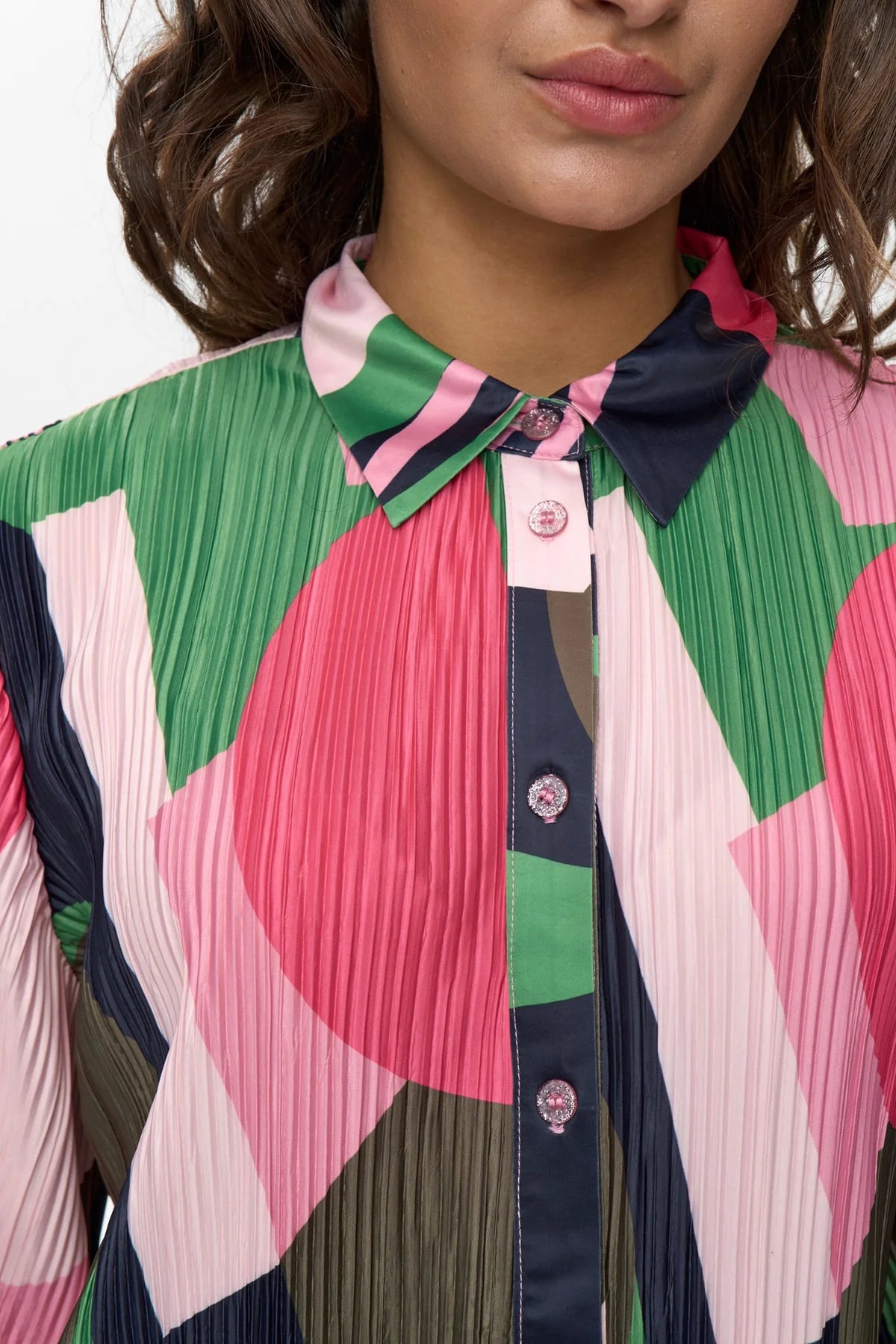 Close-up of a person wearing a colourful geometric patterned shirt.